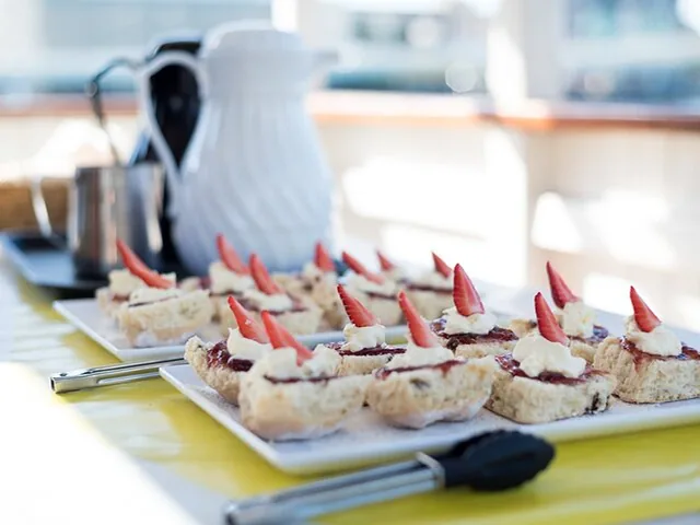 Plateau de petits gâteaux garnis de crème et de tranches de fraise