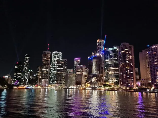 Verlichte skyline van de stad aan de overkant van de rivier bij nacht