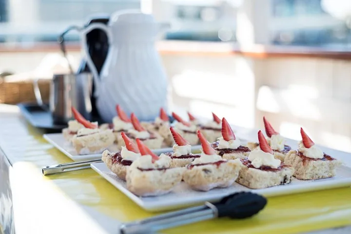 Gros plan sur des scones avec confiture et crème sur un plateau de service
