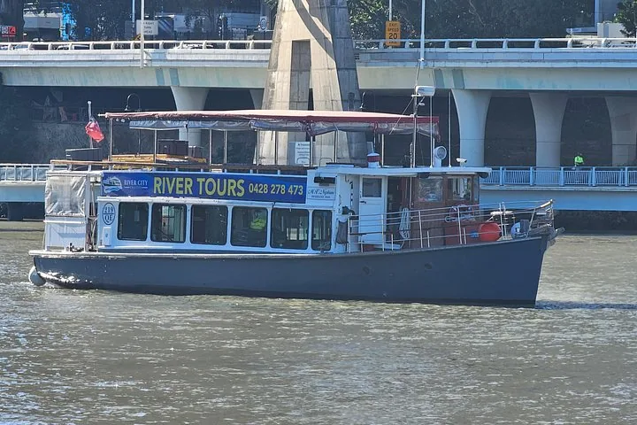 Flussrundfahrtsboot bei der Fahrt unter einer großen Brücke